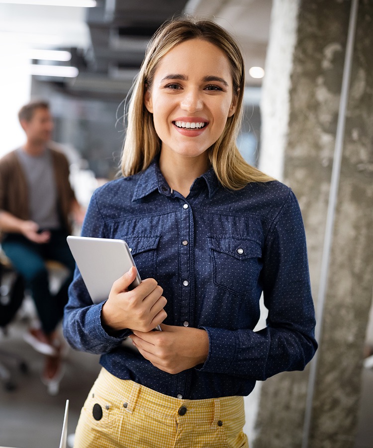 A smiling professional holding a digital tablet